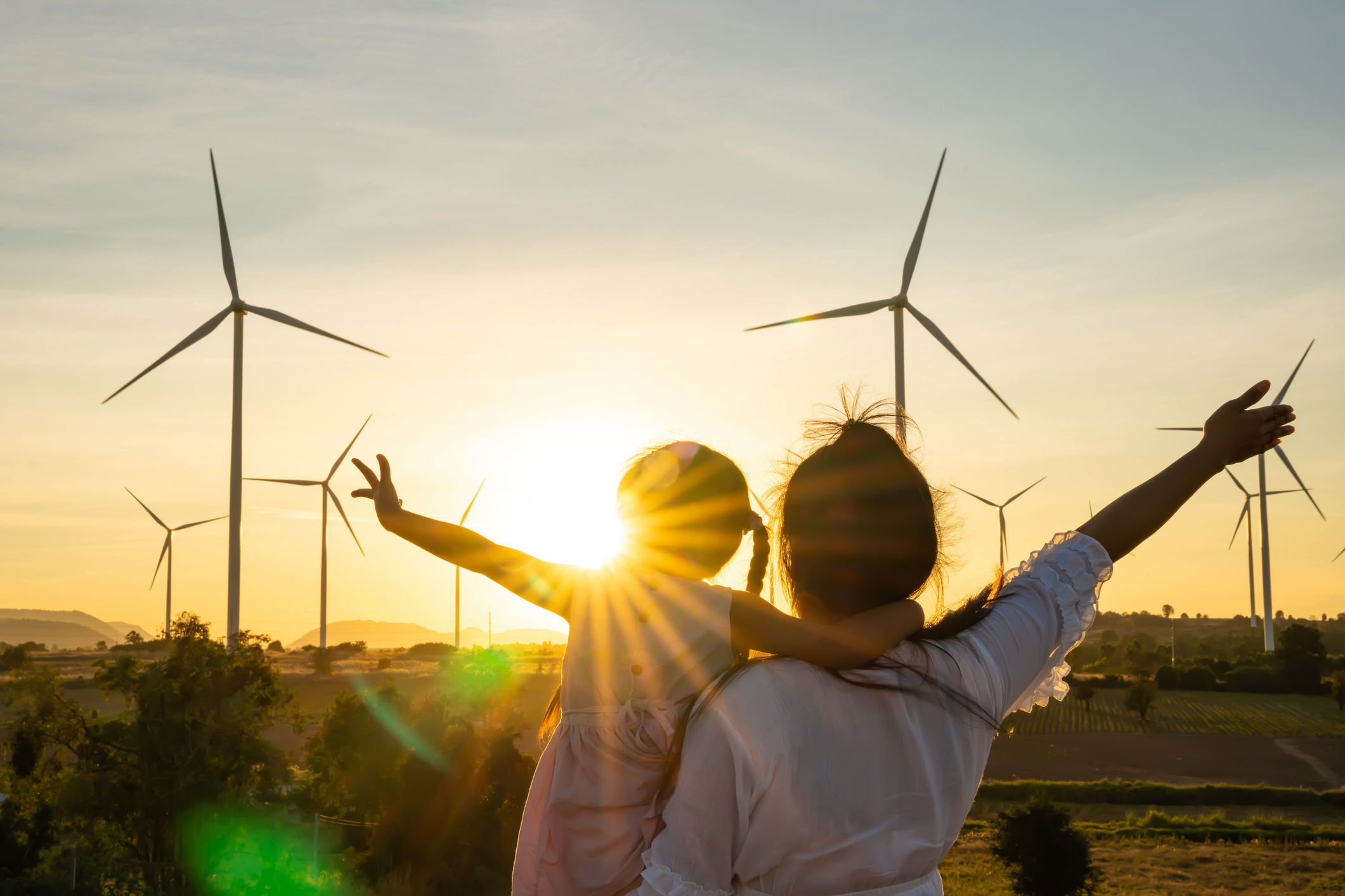 People in a community with wind turbines, symbolizing sustainable and renewable energy sources.